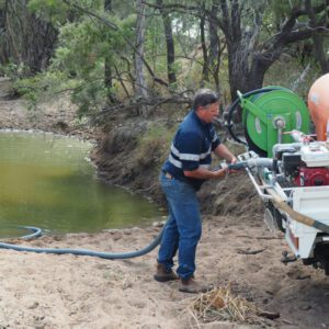 Man using pump feature on Nu-Tank Fire Fighter Unit to refill the unit from a dam/creek.